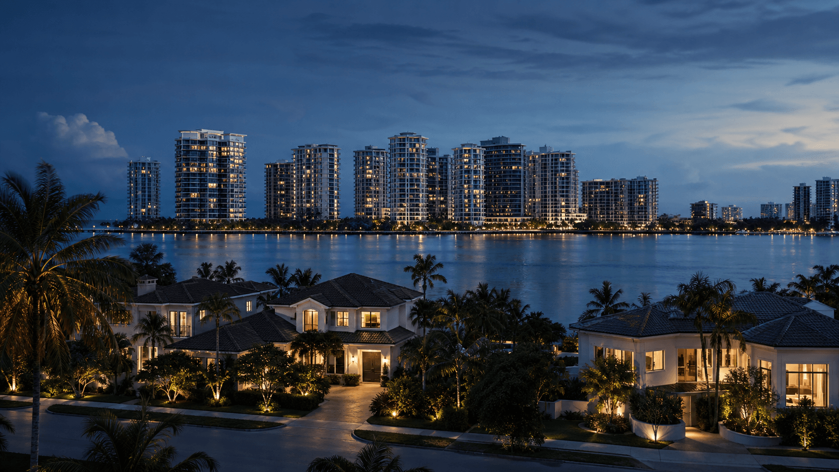 South Florida waterfront homes facing condominium towers across calm water at blue hour