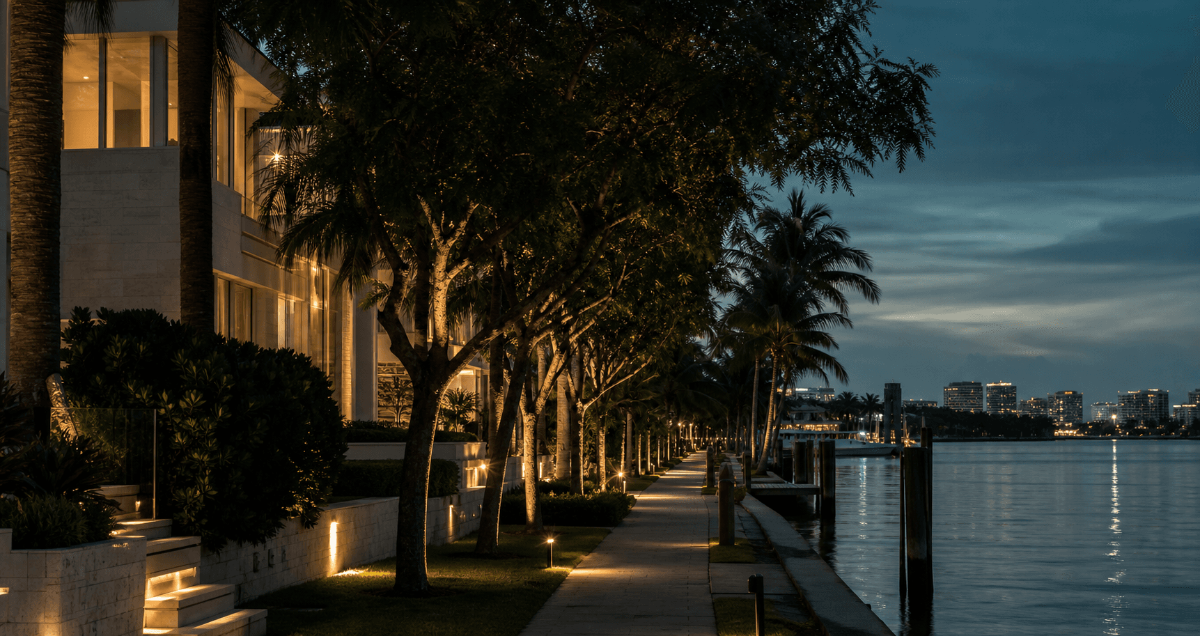 Quiet waterfront neighborhood with palms and warm lights after sunset